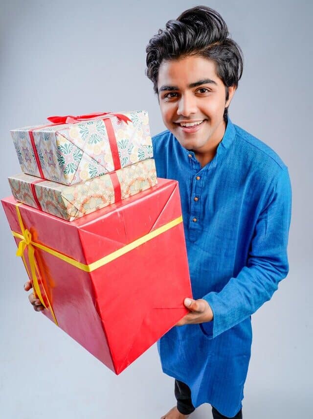 Man holding some budget gift boxes and lamp during Diwali festival
